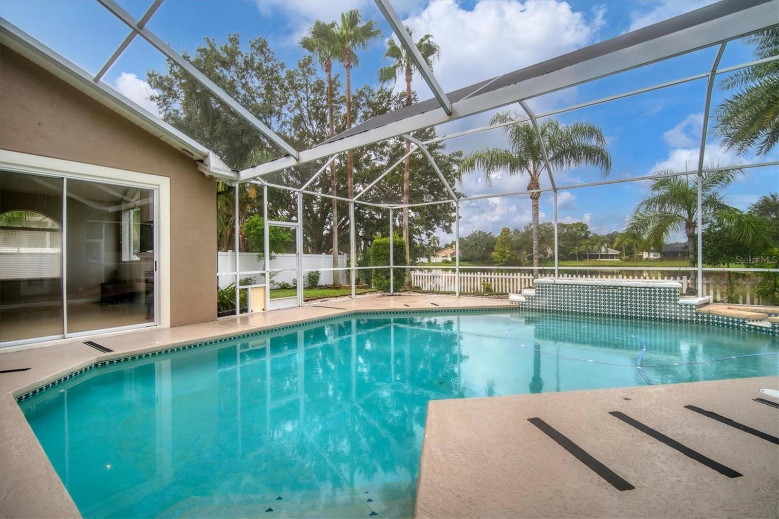 Patio overlooks backyard and pond.  Privacy fence on both sides and picket fence along back.