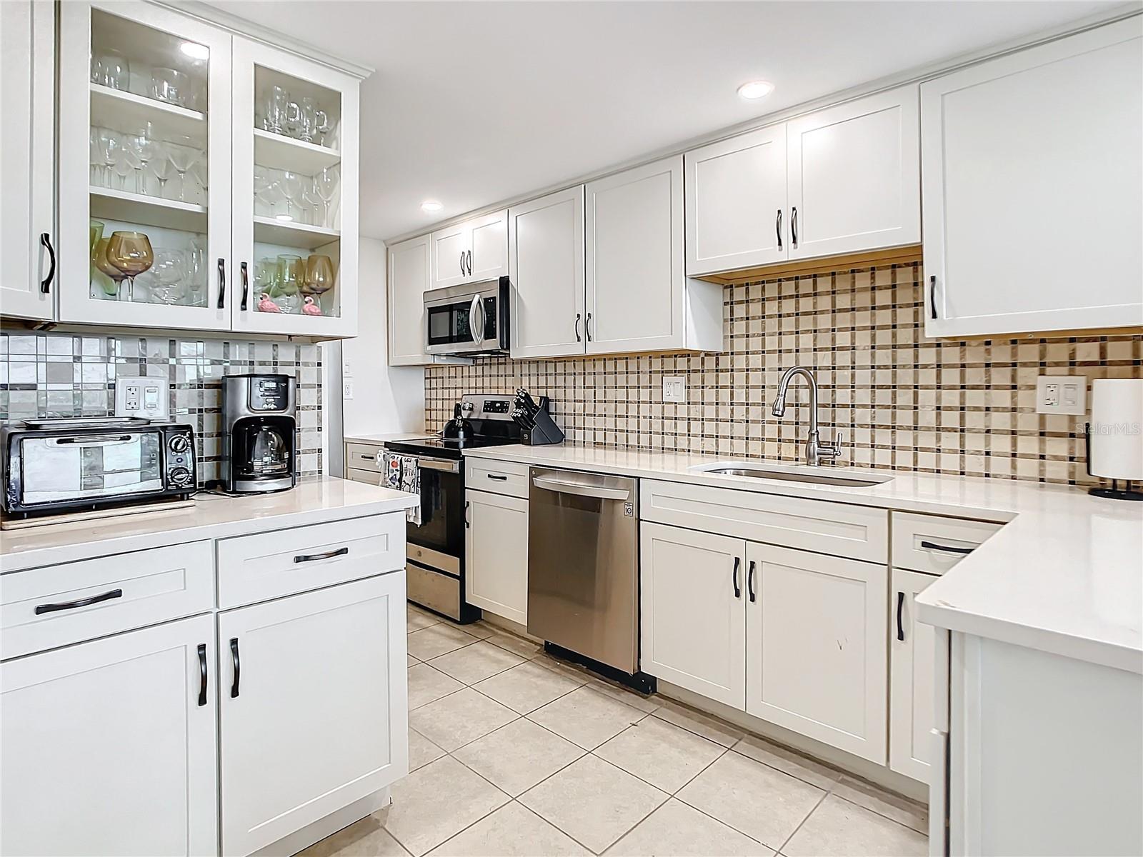 Another look at your updated kitchen that offers some glass insert cabinets and lots of storage as you can see.