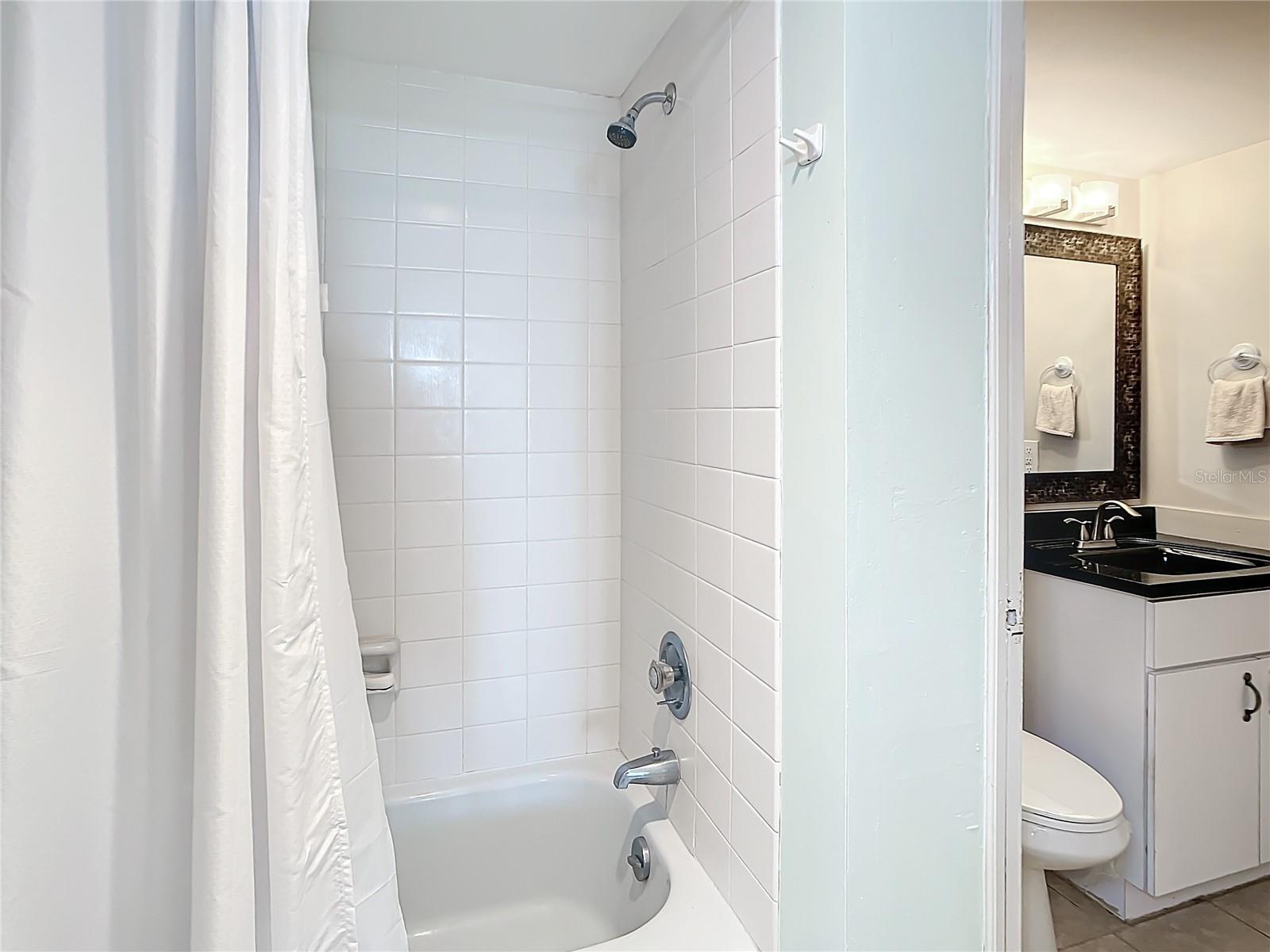 In the primary suite you have a tub with a shower.  There is a pocket door that leads to the half bath which is off of the hallway.