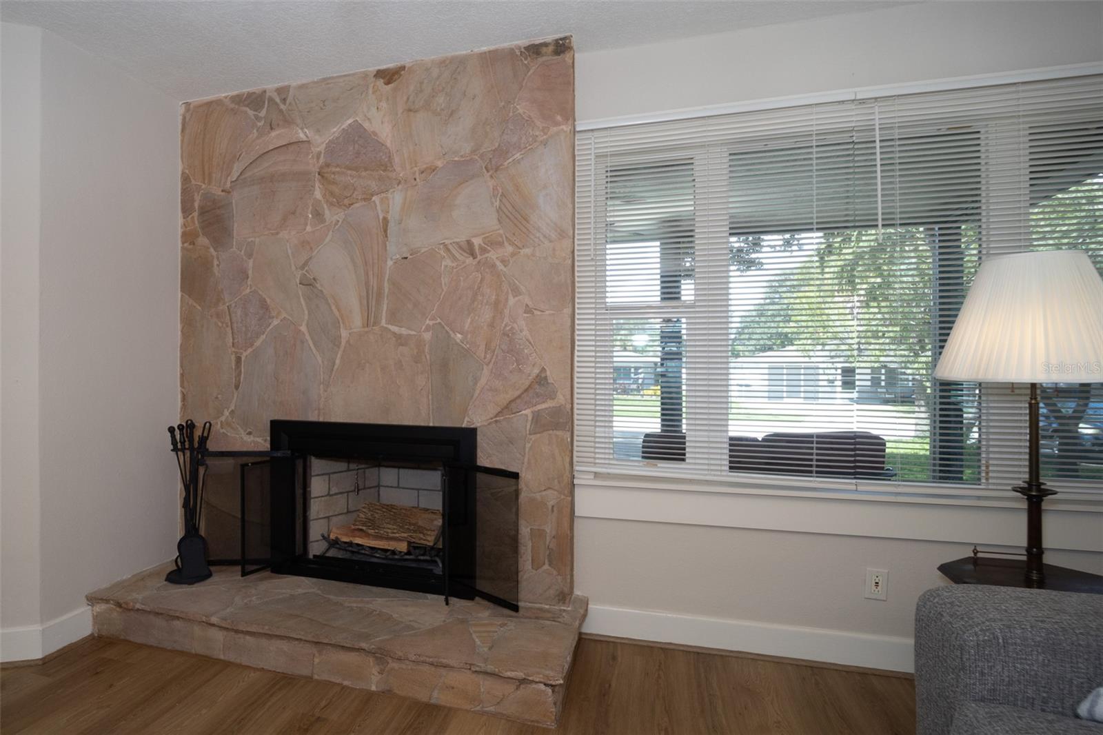 Gorgeous natural stone wood burning fireplace has new screen