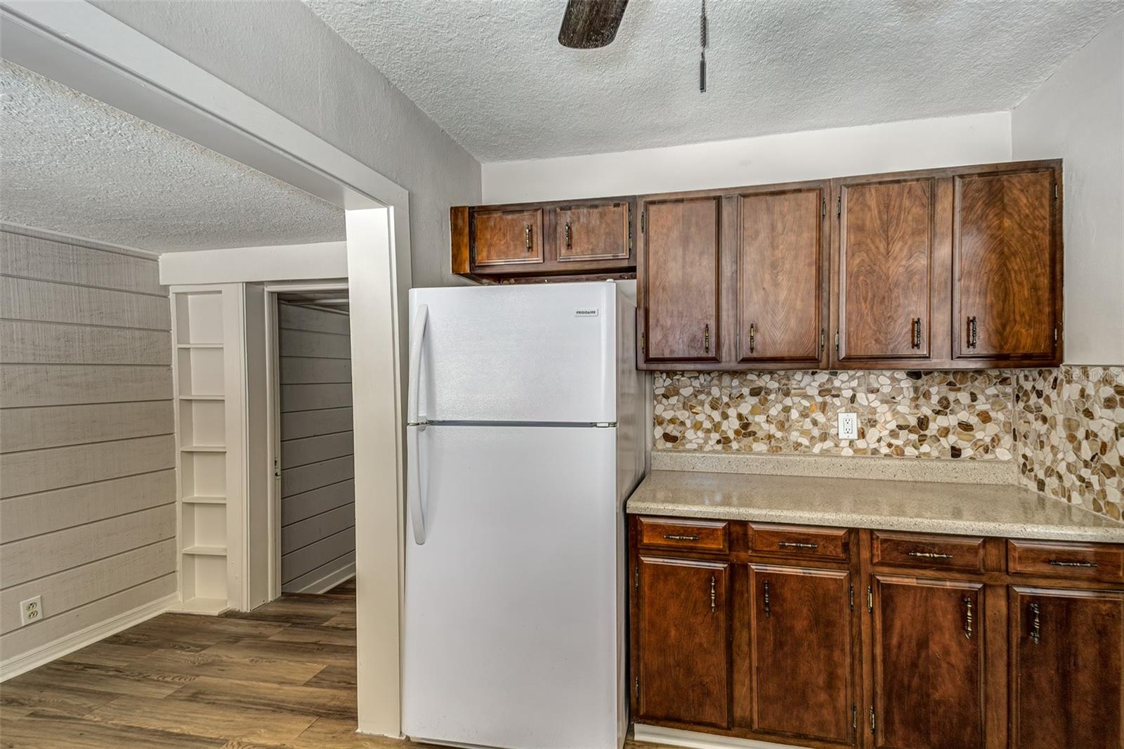 Kitchen other view with refrigerator...built-in shelves at entrance to third bedroom/office