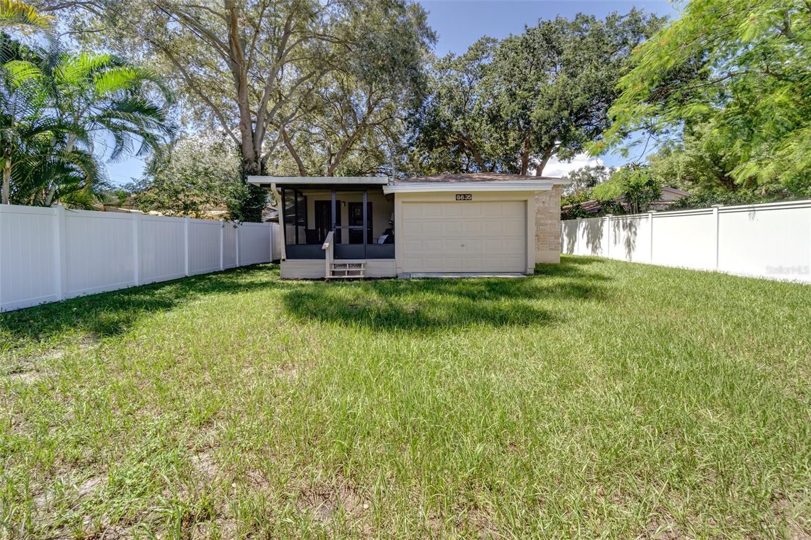 View from back yard to rear of home...rear porch and garage seen