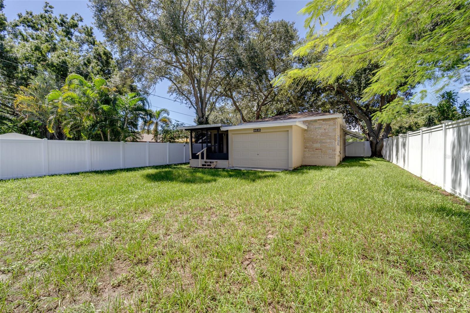 Other view from rear of yard towards home...garage and rear porch seen...fully vinyl fenced!