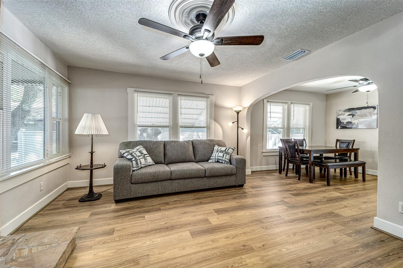 Beautiful living room with a multitude of beautifully crafted windows with large casings....large open archway flows into dining room