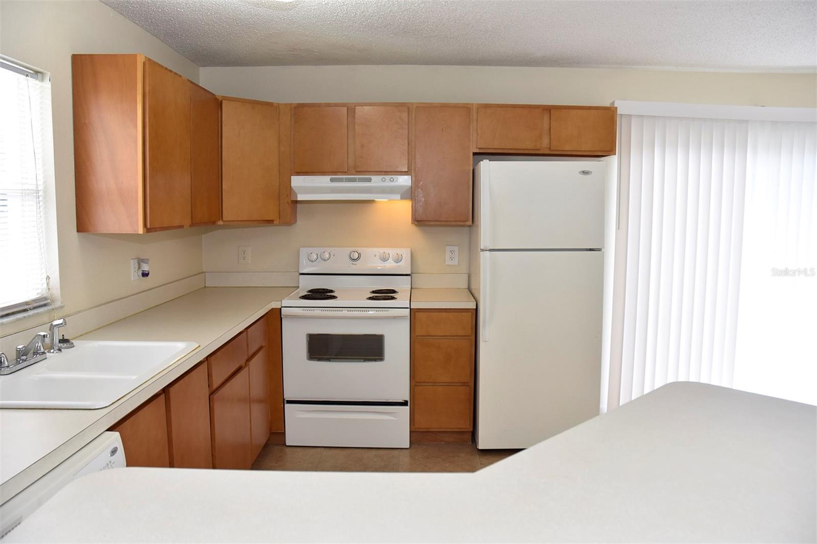 Kitchen is spacious with wood cabinets and lots of counter space.