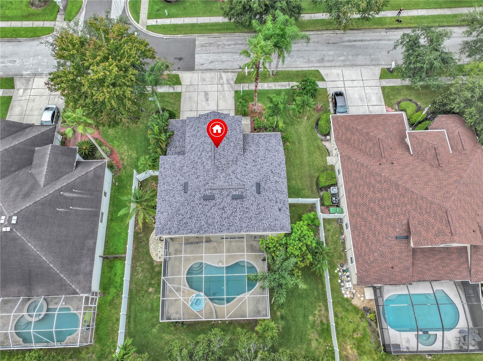 DRONE VIEW OF BACK OF HOUSE WITH SCREENED LANAI AND POOL/SPA