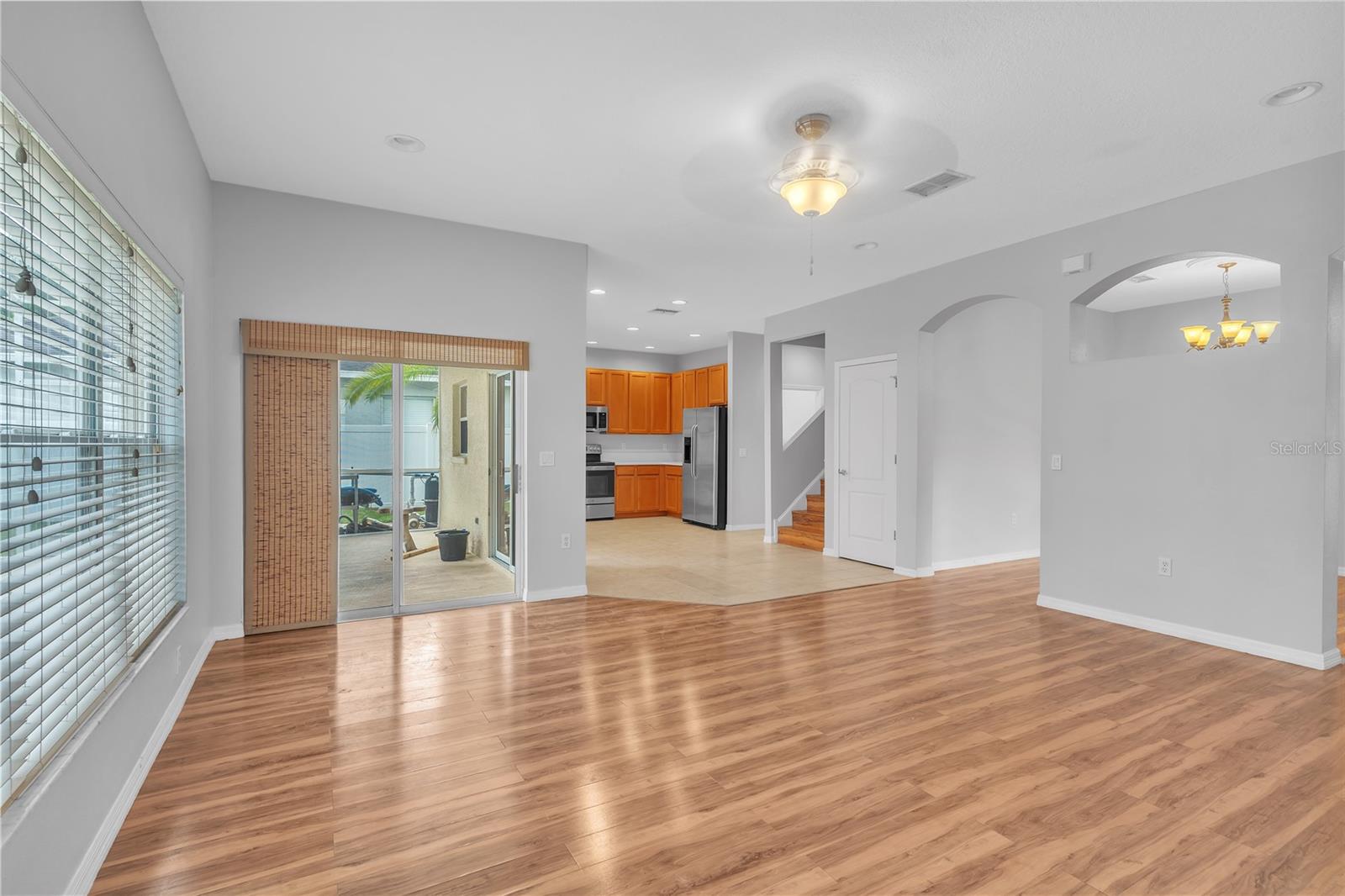 FAMILY ROOM WITH KITCHEN, STAIRWAY TO 2ND FLOOR, ENTRY TO LANAI AND DINING ROOM OFF TO THE RIGHT