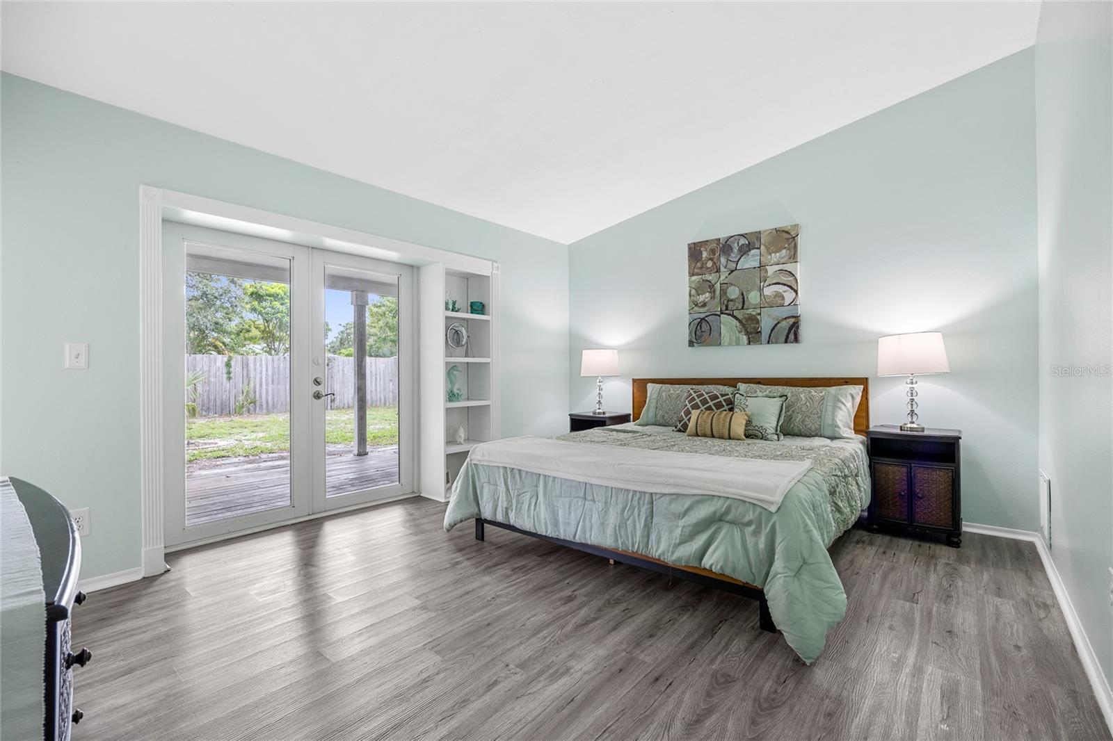 The Primary Bedroom as Vaulted Ceilings and direct access thru double doors the the back deck and yard.