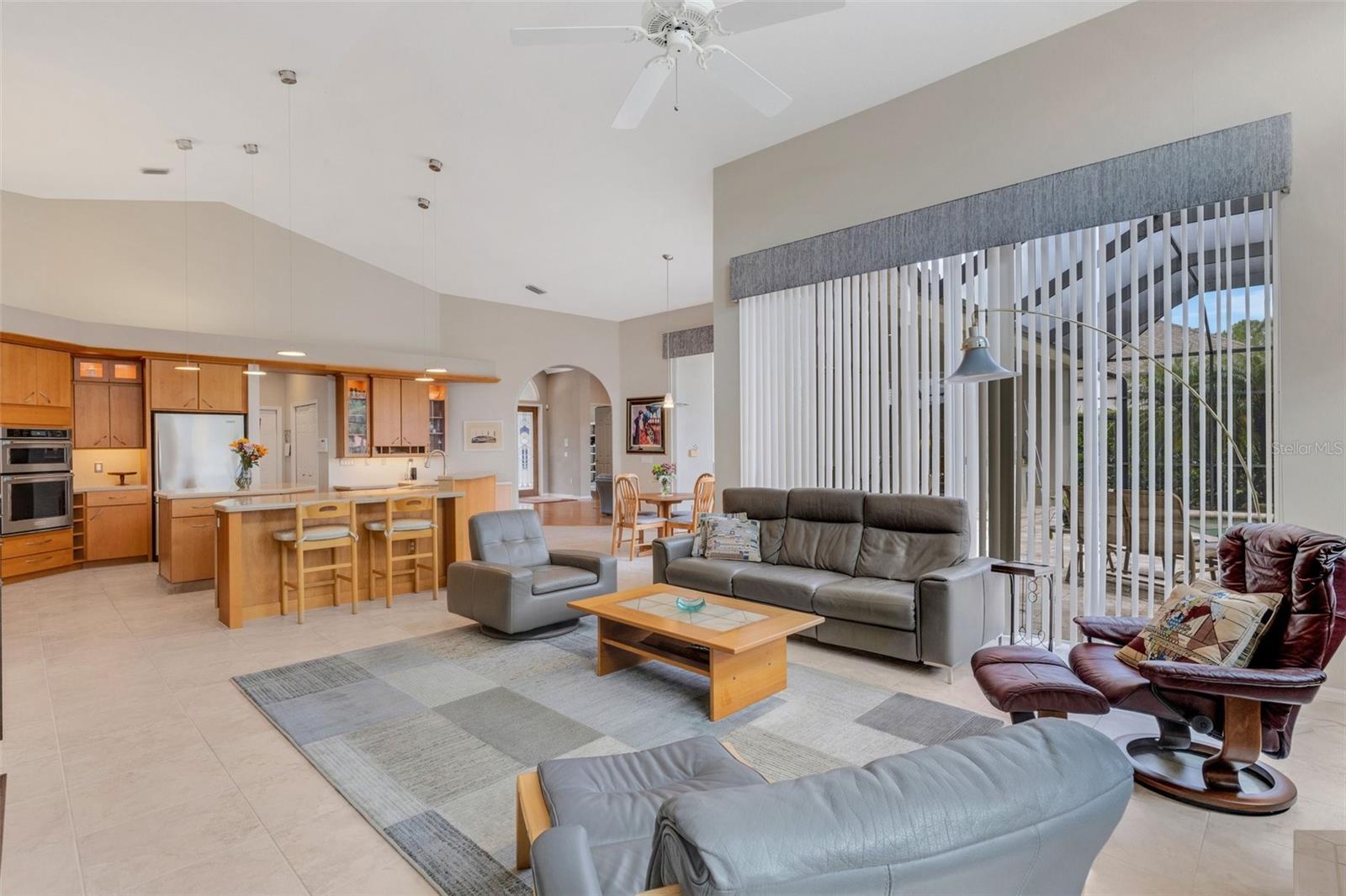 The family room adjoins the kitchen and has tall glass sliders to the lanai and pool!