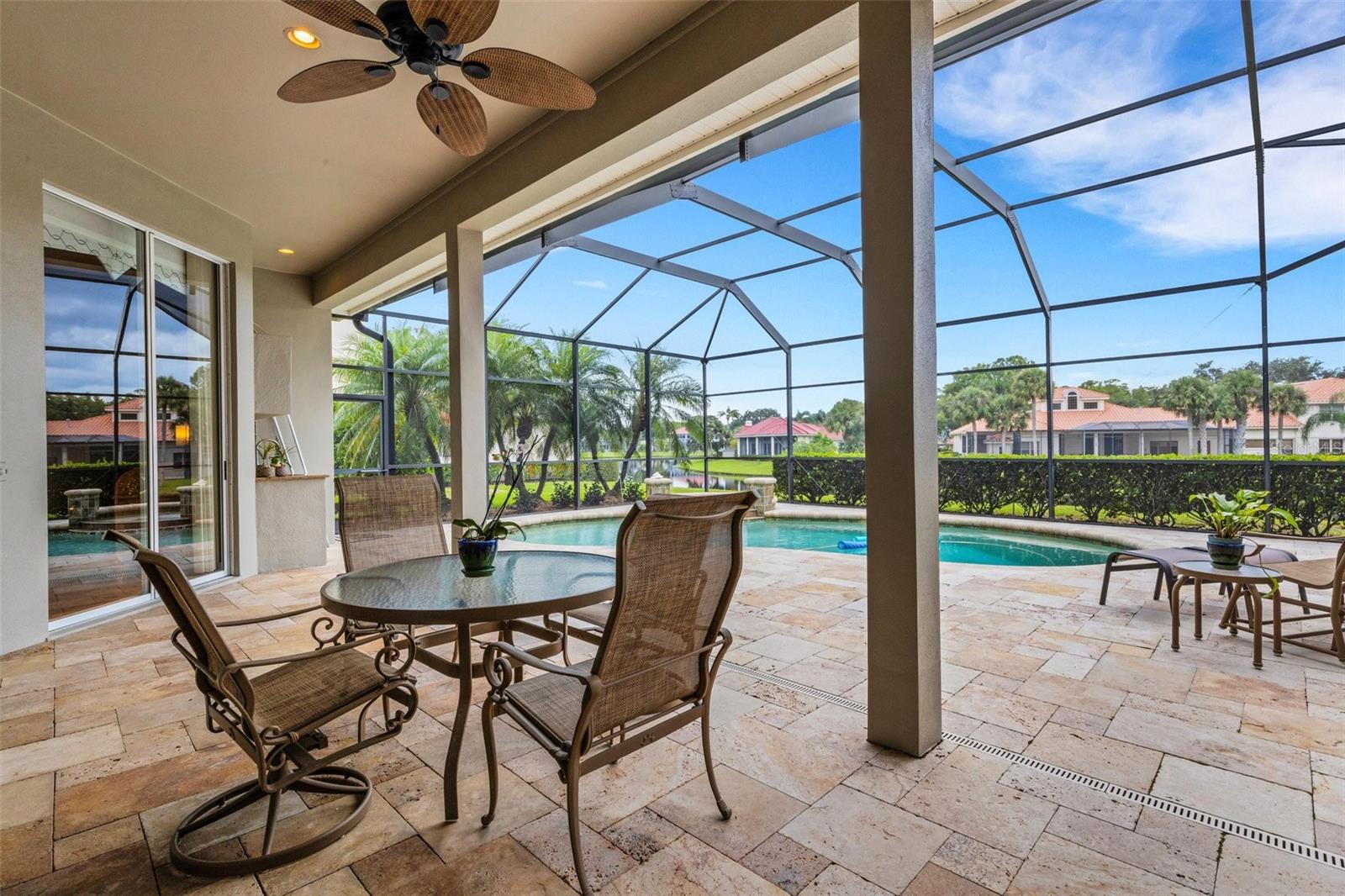 Pavers on lanai with large covered area and view of the pond