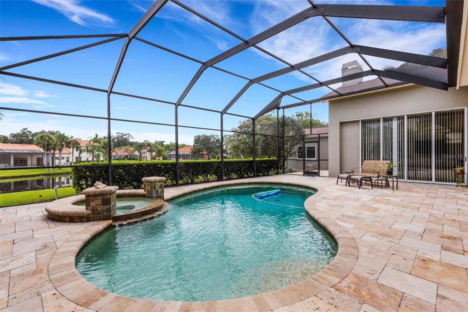 Pool and pond surrounded by gorgeous pavers