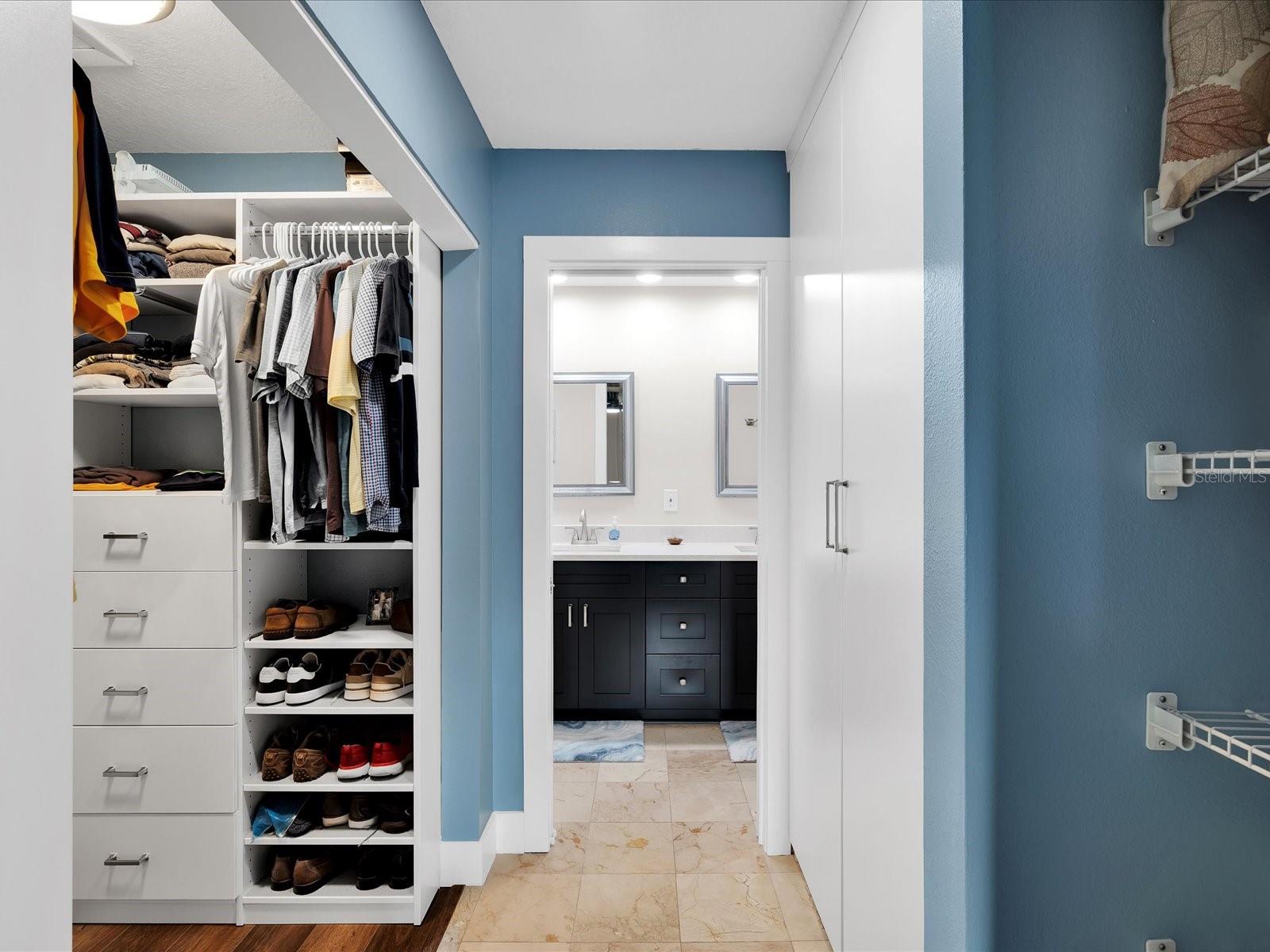 Master bedroom features a walk in closet & wall closet w/ custom storage by Closets By Design