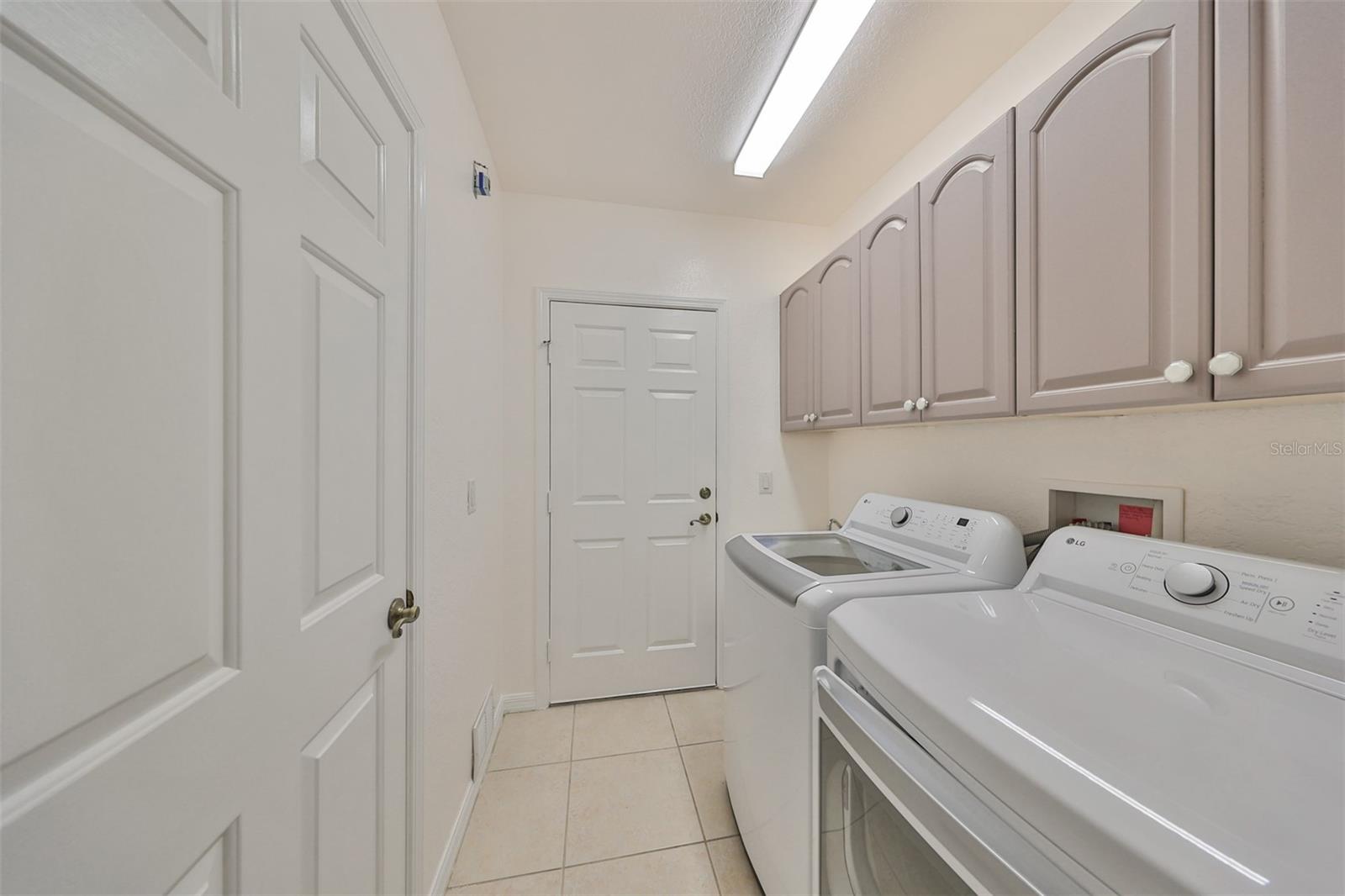 Walk in laundry room with BRAND NEW WASHER AND DRYER, inside with storage and sink. Leads to a 2 car epoxy floor garage and includes Charbroil Grill with purchase of house.