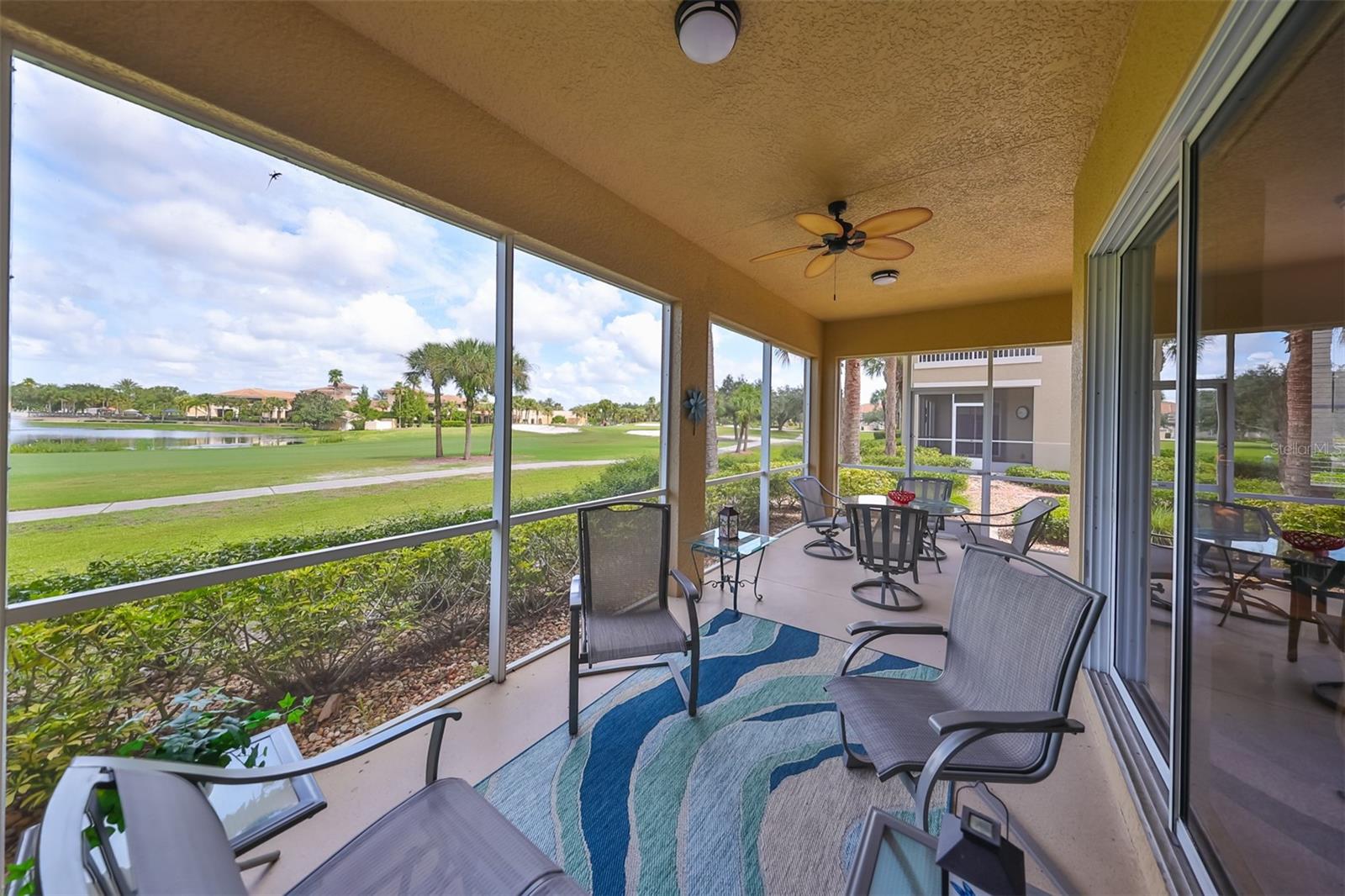 Screened patio with beautiful golf course view, a pond and the Renaissance Clubhouse in the distance and a tropical ceiling fan for ultimate comfort.