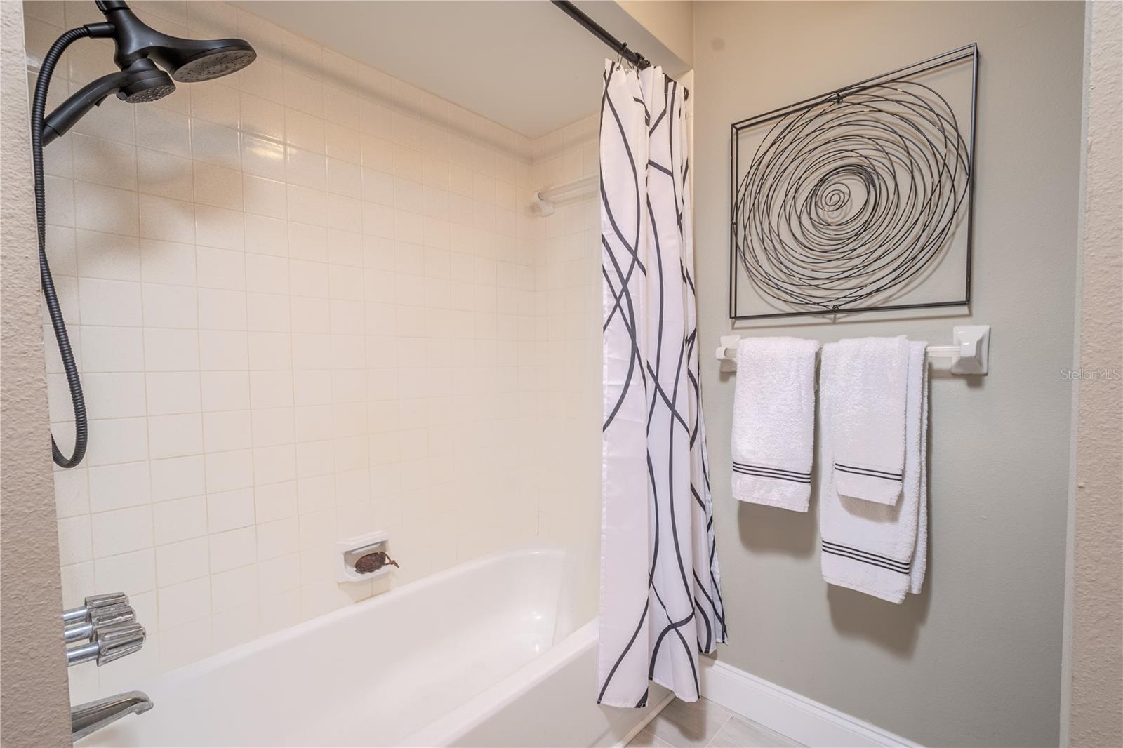 Bathroom 2 features a tiled tub with shower.