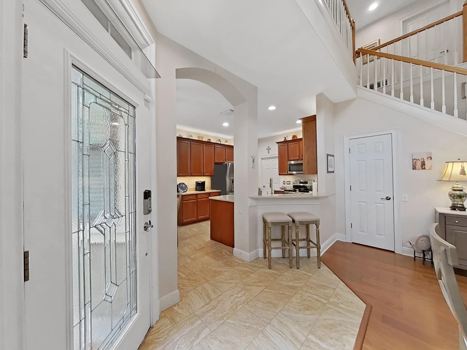 Kitchen opens into great room. Door at end of bar understairs has custom shelving built in