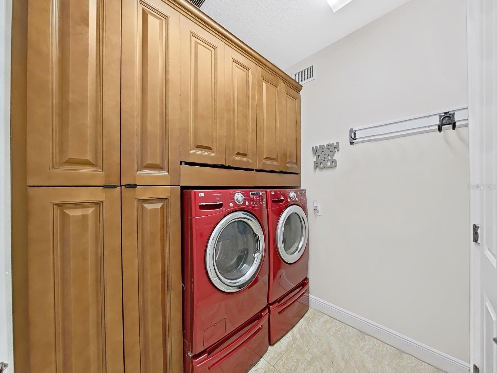 Now that is a laundry.  Custom cabinetry with pull out shelves for convenience offers so much storage.  Newer LG washer and dryer with storage drawers under each.