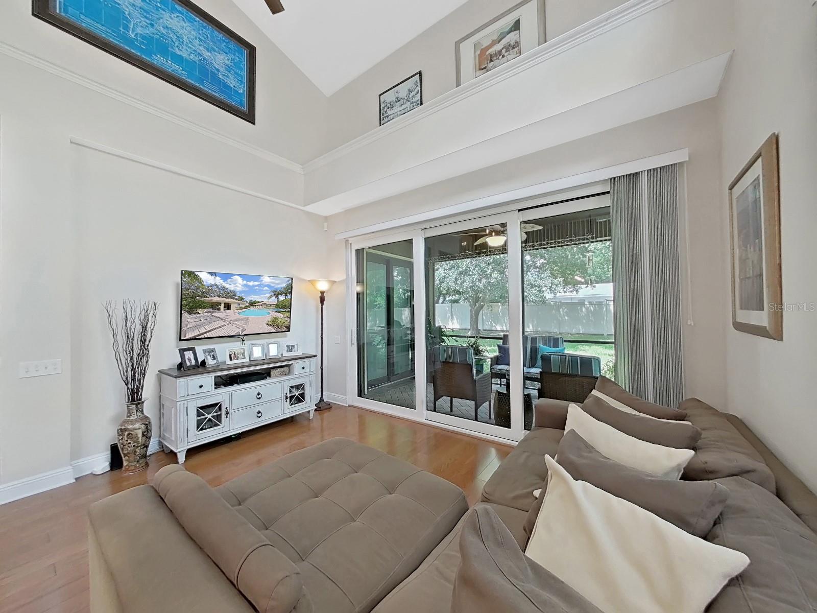 2 story living room looks out onto screen porch with pavers. SLIDERS AND ALL WINDOWS ARE 2018 HURRICANE IMPACT.  NOT IN A FLOOD ZONE!