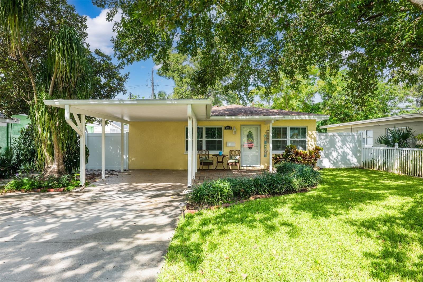 This lovely cottage home is tucked under the dappled shade of a beautiful, mature tree and framed by a lush lawn.