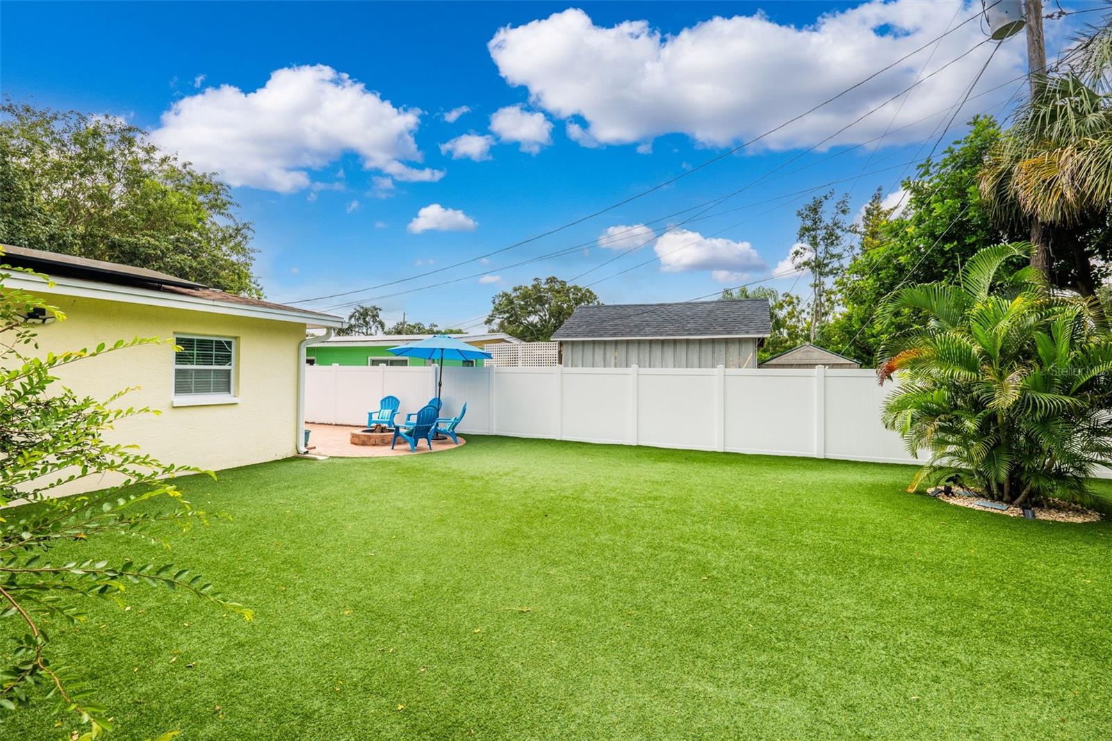 Pet-friendly turf, vinyl privacy fence, and storage shed make for a well-equipped rear lawn.