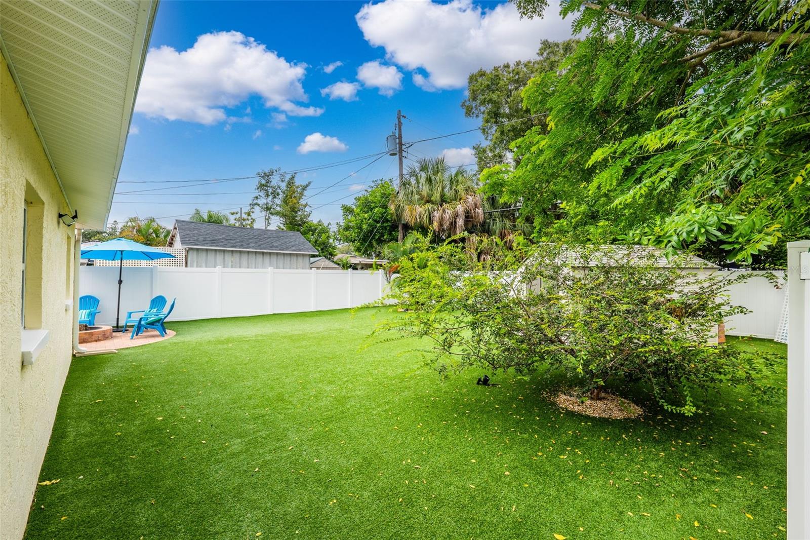 Pet-friendly turf, vinyl privacy fence, and storage shed make for a well-equipped rear lawn.