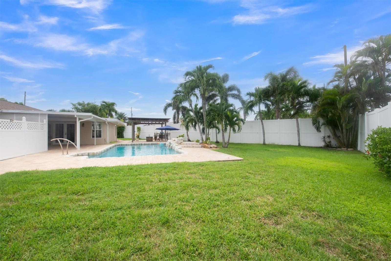 Back yard, pool, covered patio with Tiki Hut