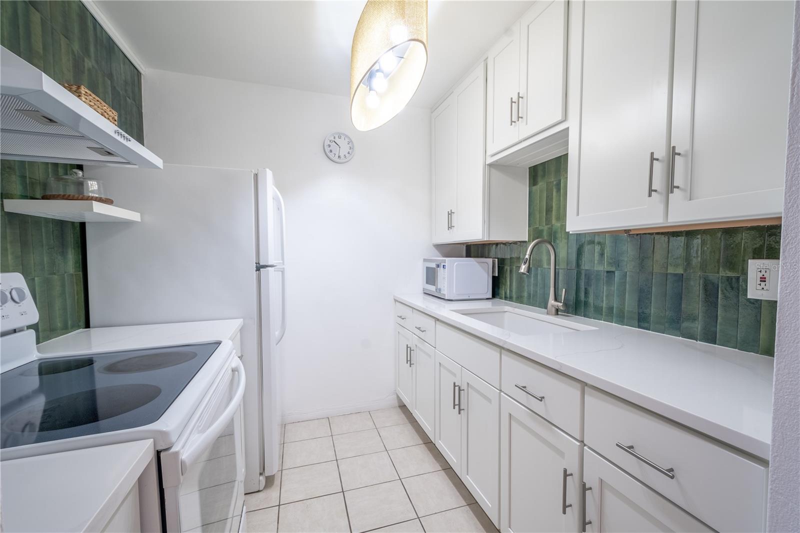 The kitchen features a range with exhaust hood, a refrigerator/freezer and plenty of counter and cabinet space.