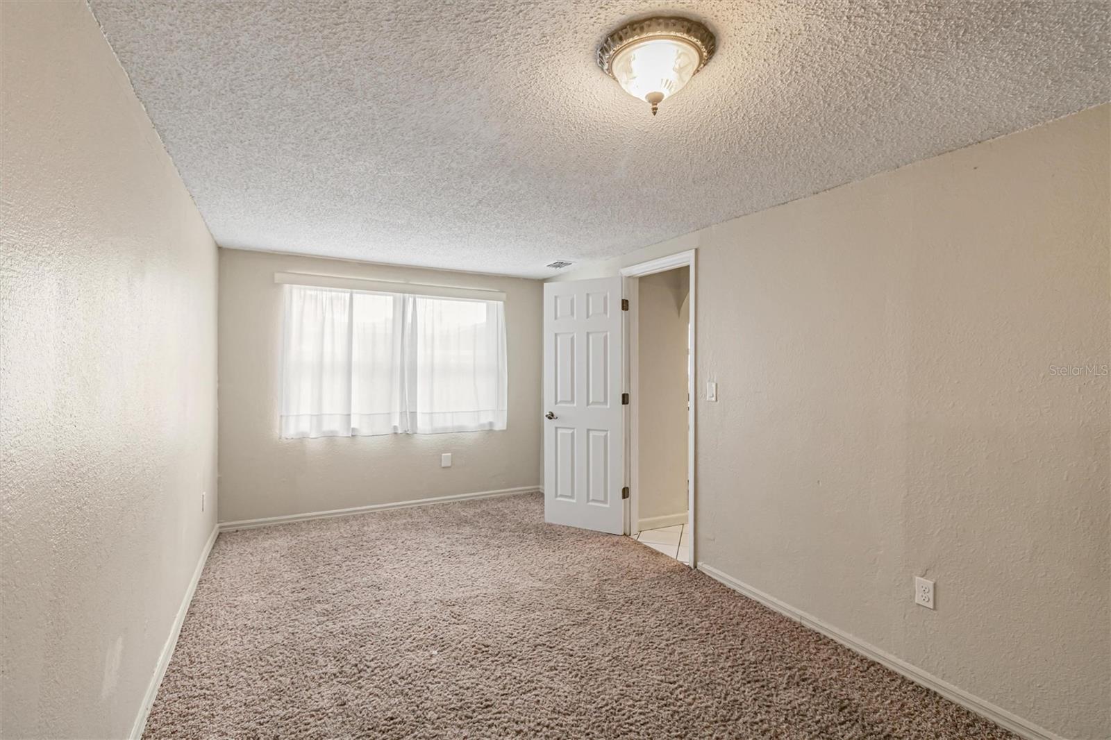 Photo faces walk-in closet with windows.