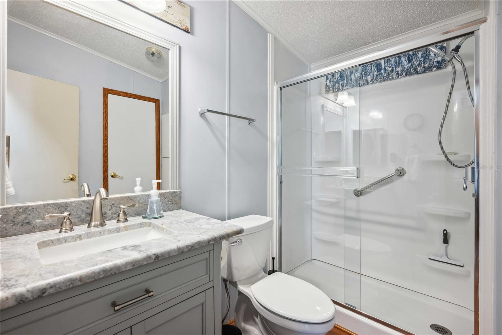 Guest bath has updated vanity, step-in shower, high toilet and new fixtures.