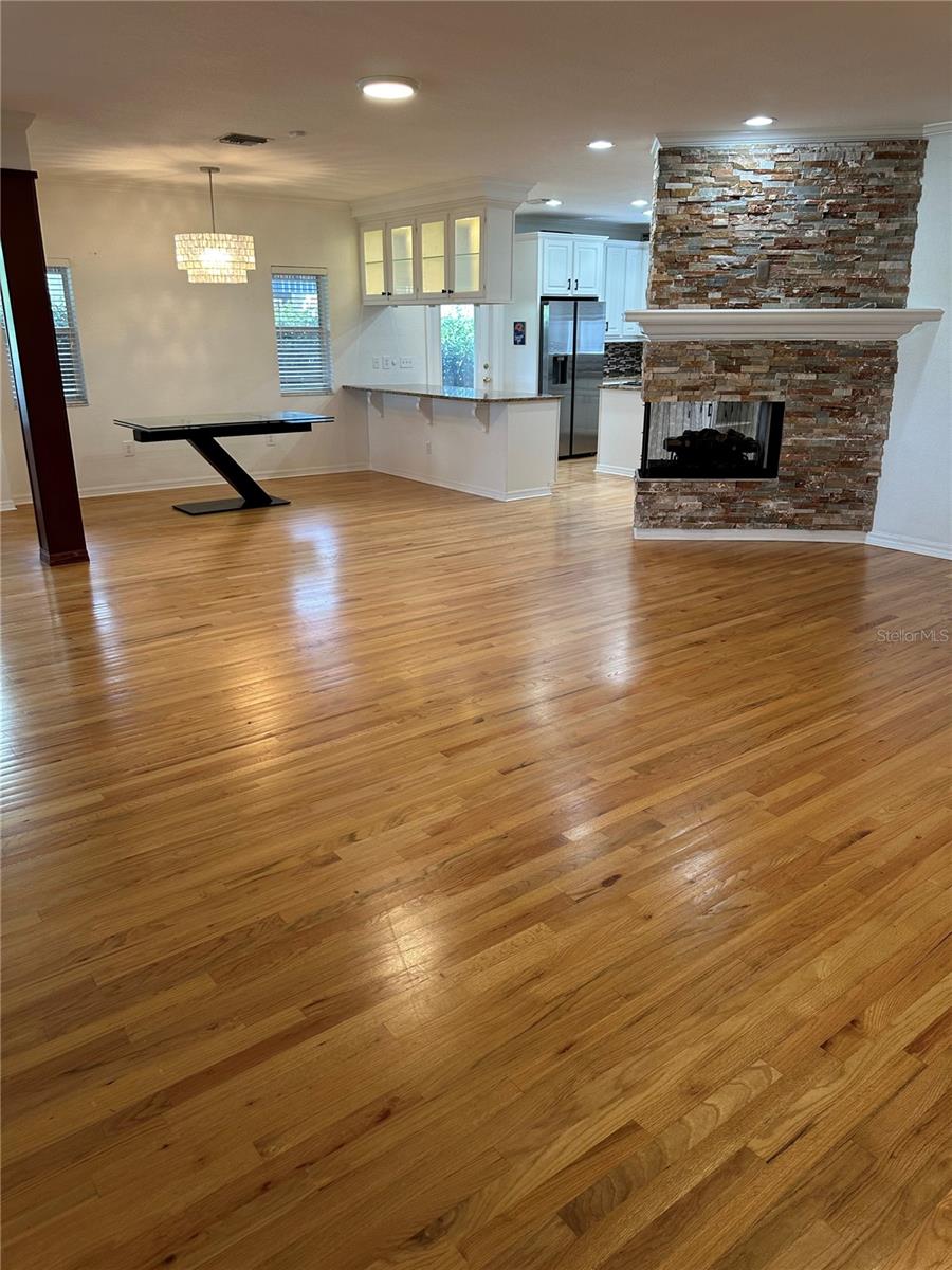 view of living, dining and kitchen (with fireplace) taken from staircase