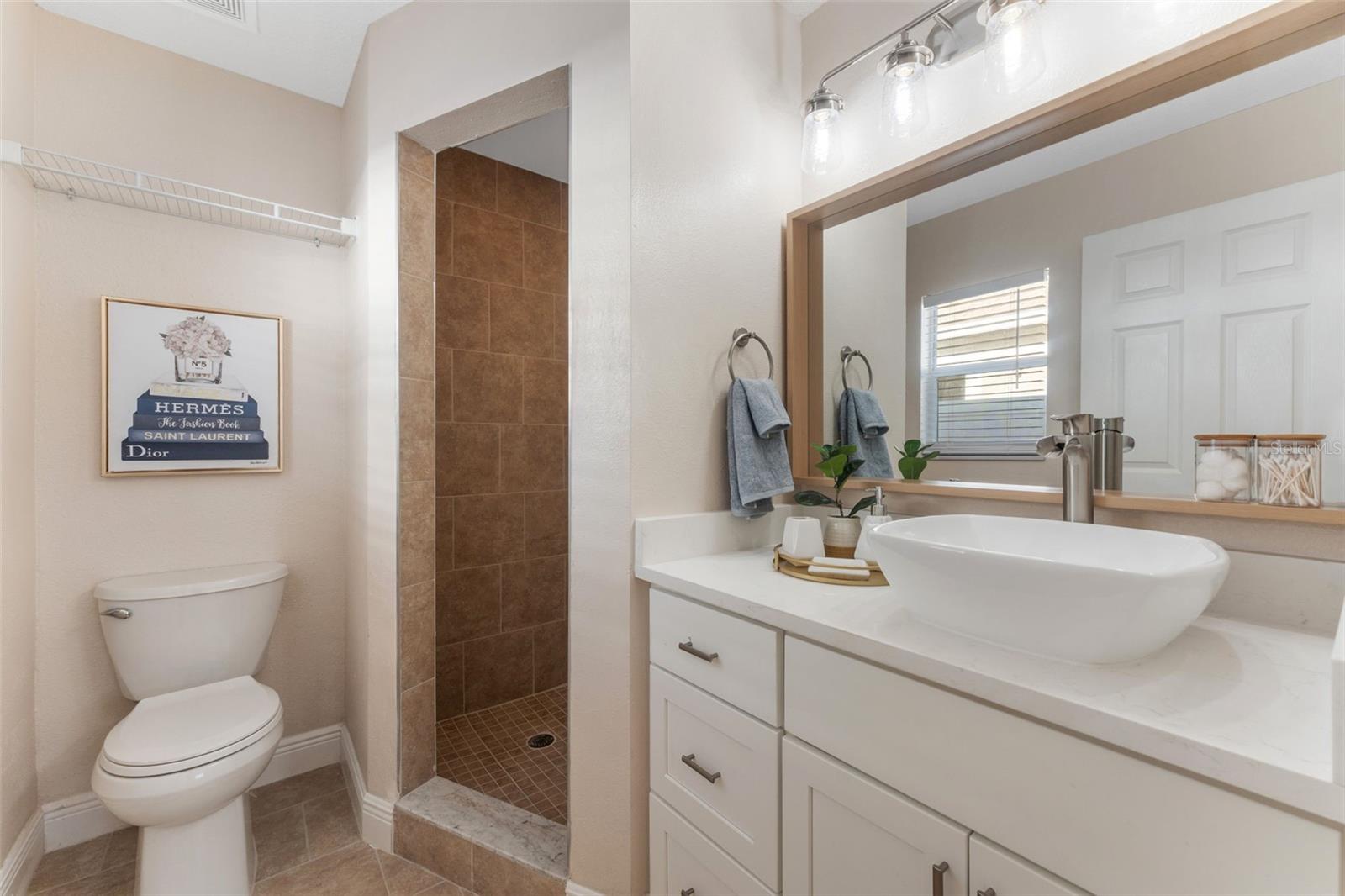 master bathroom with quartz counter and walk in shower