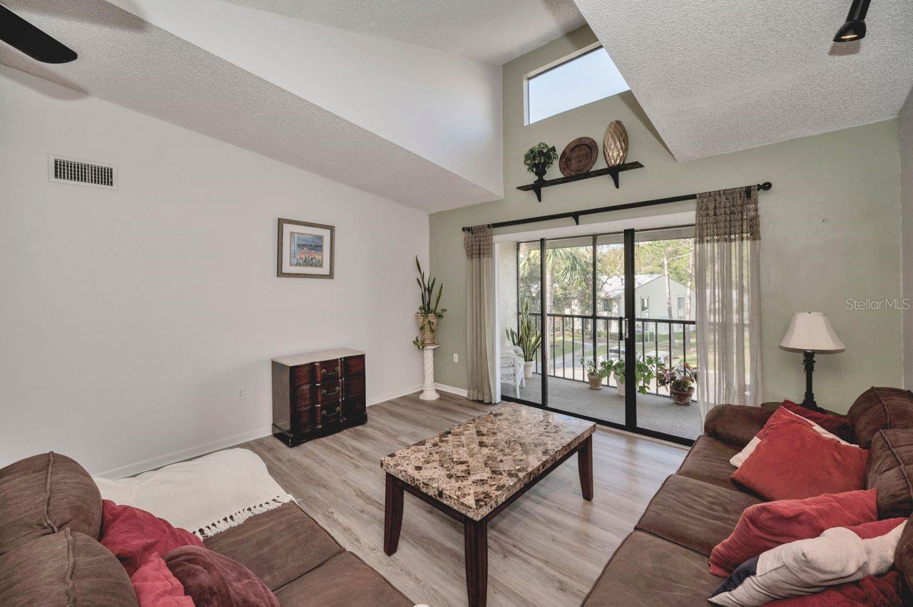 Comfortable living room with screened balcony and triple sliders to let light and air in