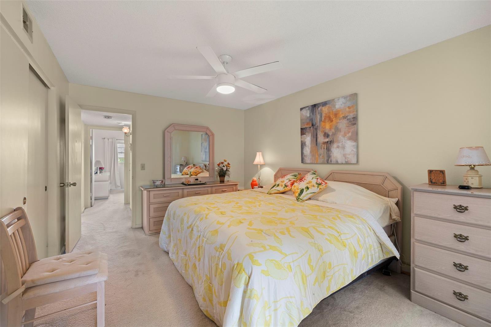 Another view of the primary bedroom toward the hallway, secondary bathroom and secondary bedroom.