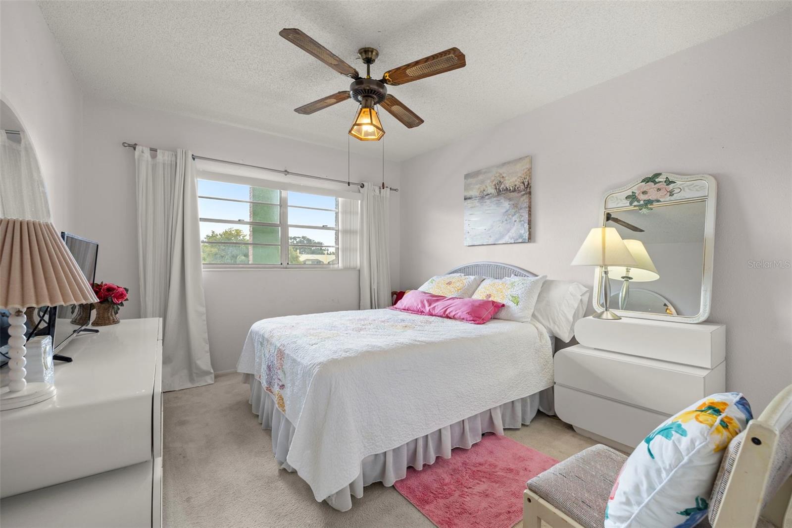 Good sized secondary bedroom featuring ceiling fan, built-in closet and plush carpeting.