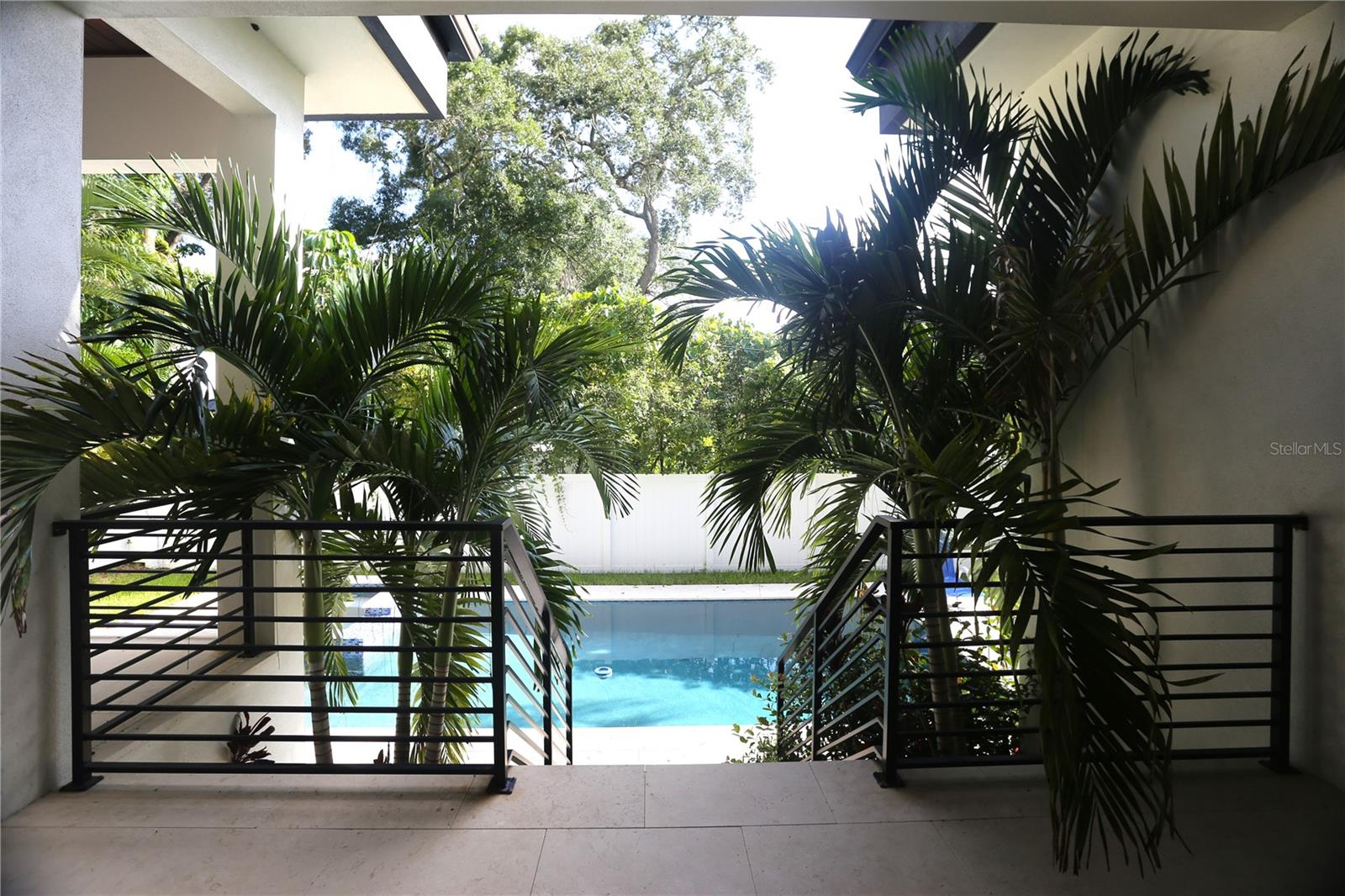 Looking from the Great Room to the lanai and pool with tropical landscaping.