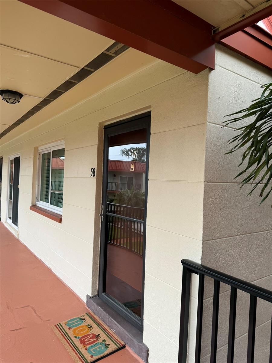 View of front Door, Living Room Window and Dining Room Sliders