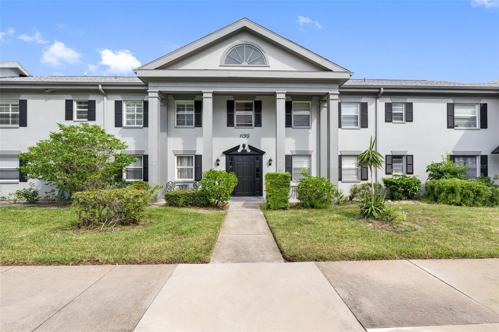 The central entrance is particularly striking, featuring a grand pediment supported by sturdy columns, lending a distinguished and welcoming air to the facade.