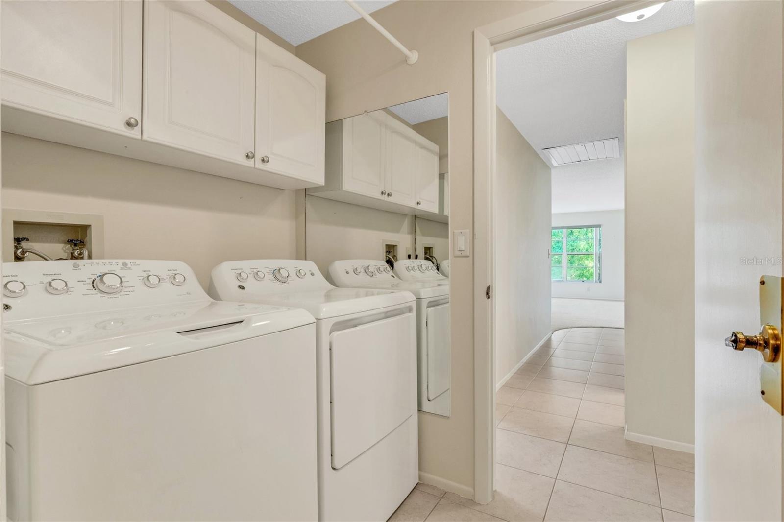 Laundry room with utility sink & extra cabinets nicely located between hall & garage~