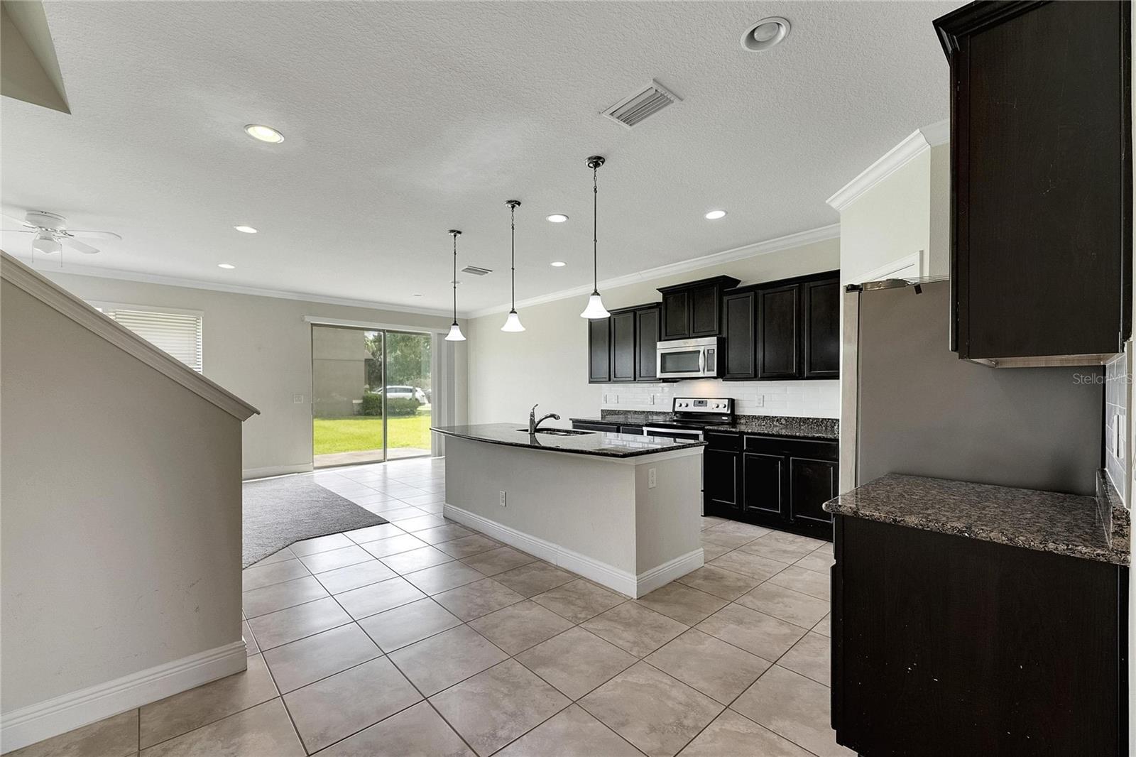 Kitchen with Grainte Countertops, Stainless Steel Appliances, Pendant and Recess Lighting