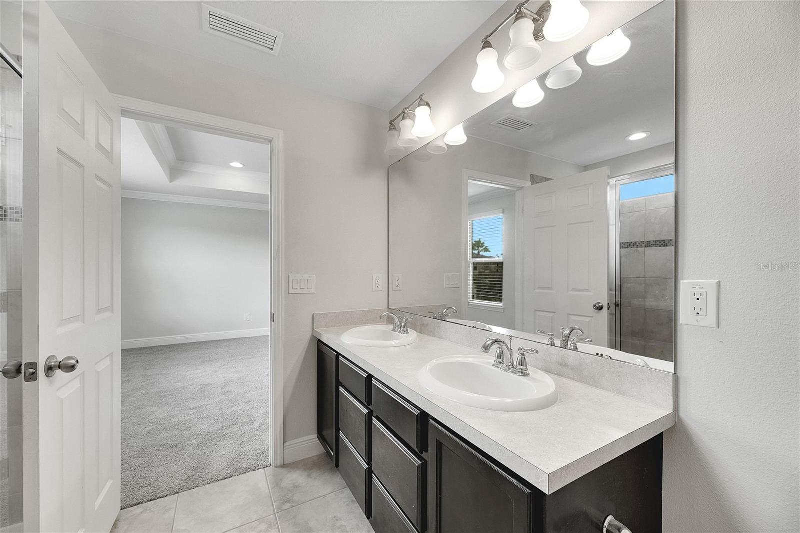 Primary Bathroom with Dual Sinks, Linen Closet and Shower Stall