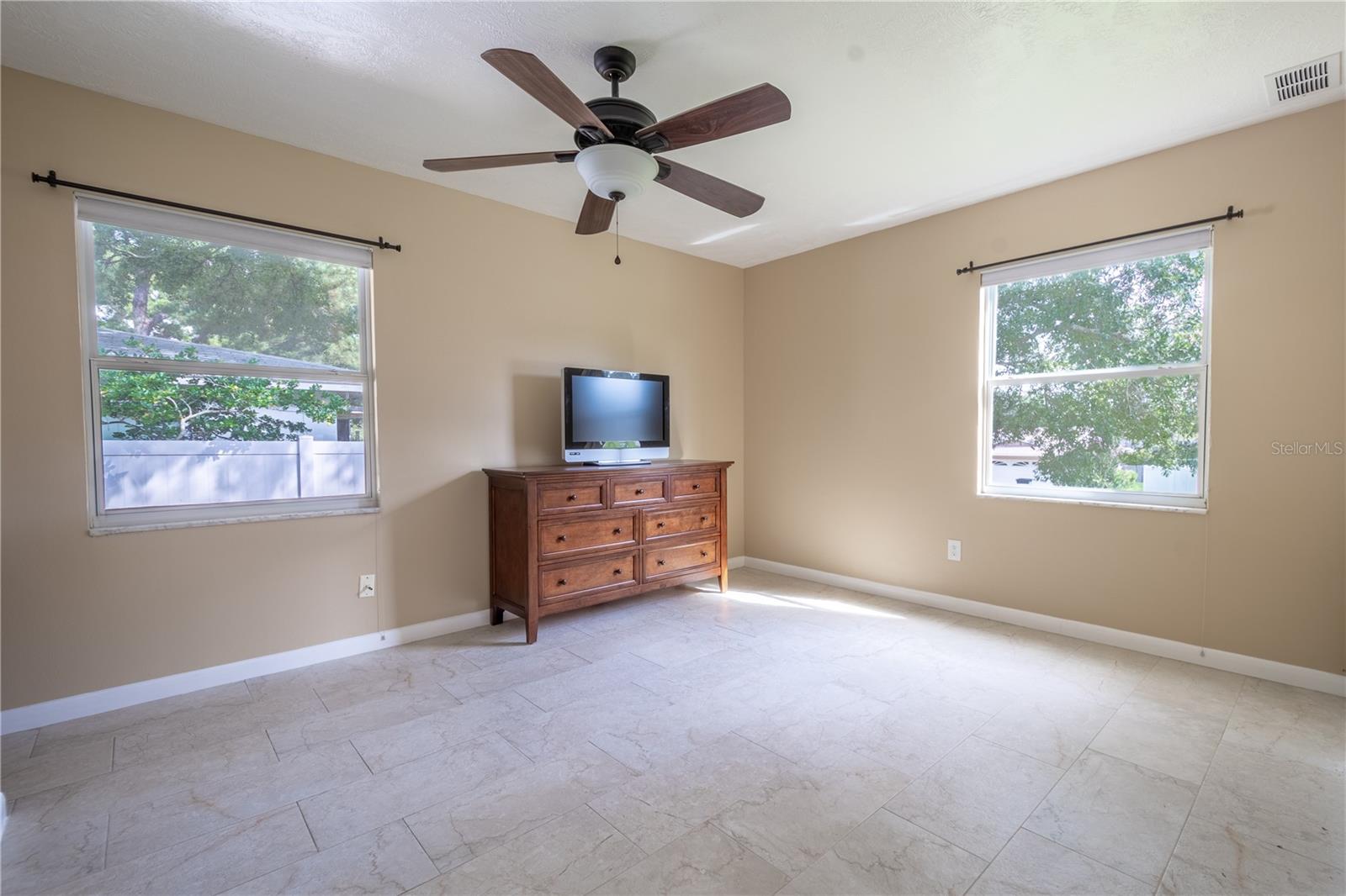 The primary bedroom features ceramic tile flooring.