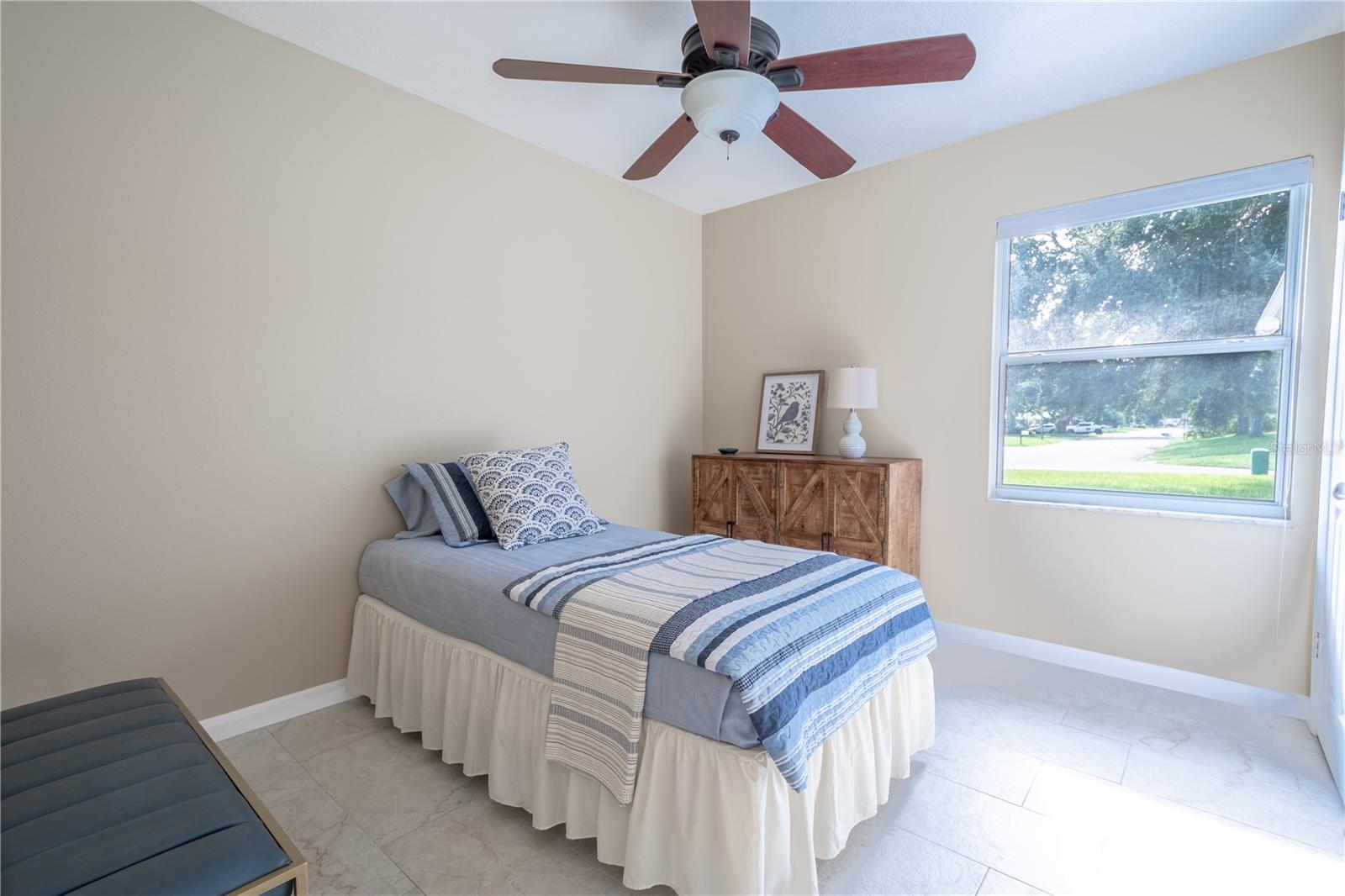 Bedroom 3 is 9'.10" x 10'.10" and features ceramic tile flooring, a ceiling fan with light kit and built-in closet.