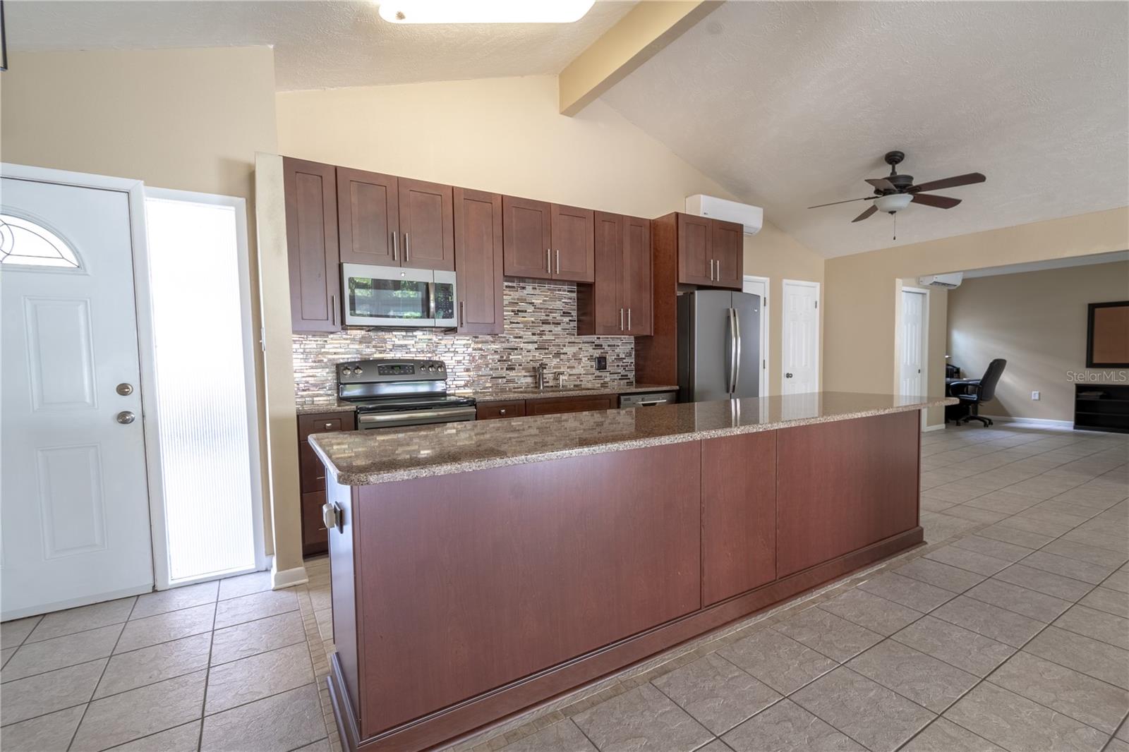 The kitchen features a breakfast bar with granite countertop.