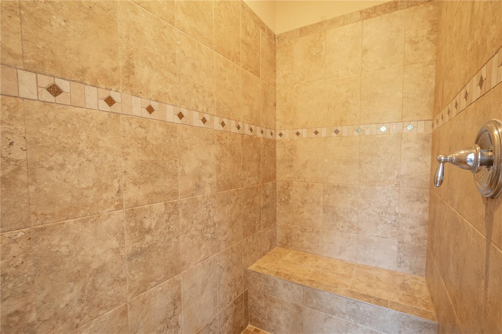 The ensuite walk-in shower features a tiled walk-in shower with built in bench.