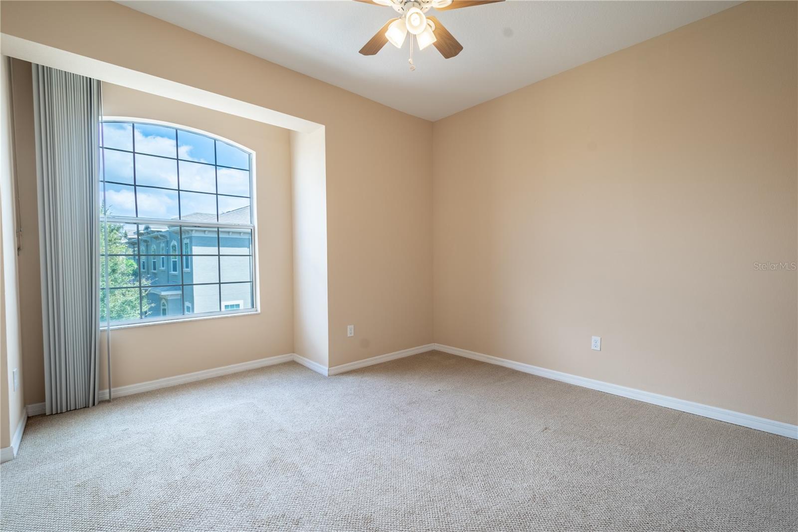 The second bedroom offers a cozy space with its soft, neutral-toned carpet and color palette. A charming nook, perfect for a window seat, adds a touch of character, while the ceiling fan with a light kit ensures comfort year-round.