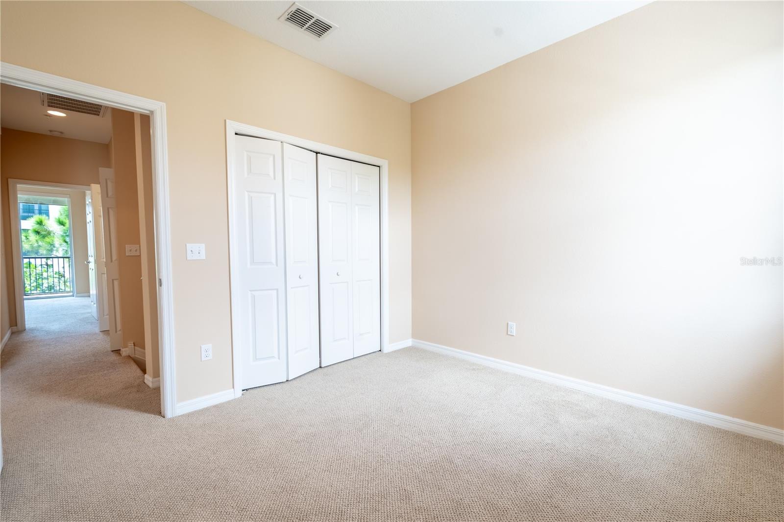 The third bedroom has a neutral-toned carpet and color palette,  and a built-in closet.