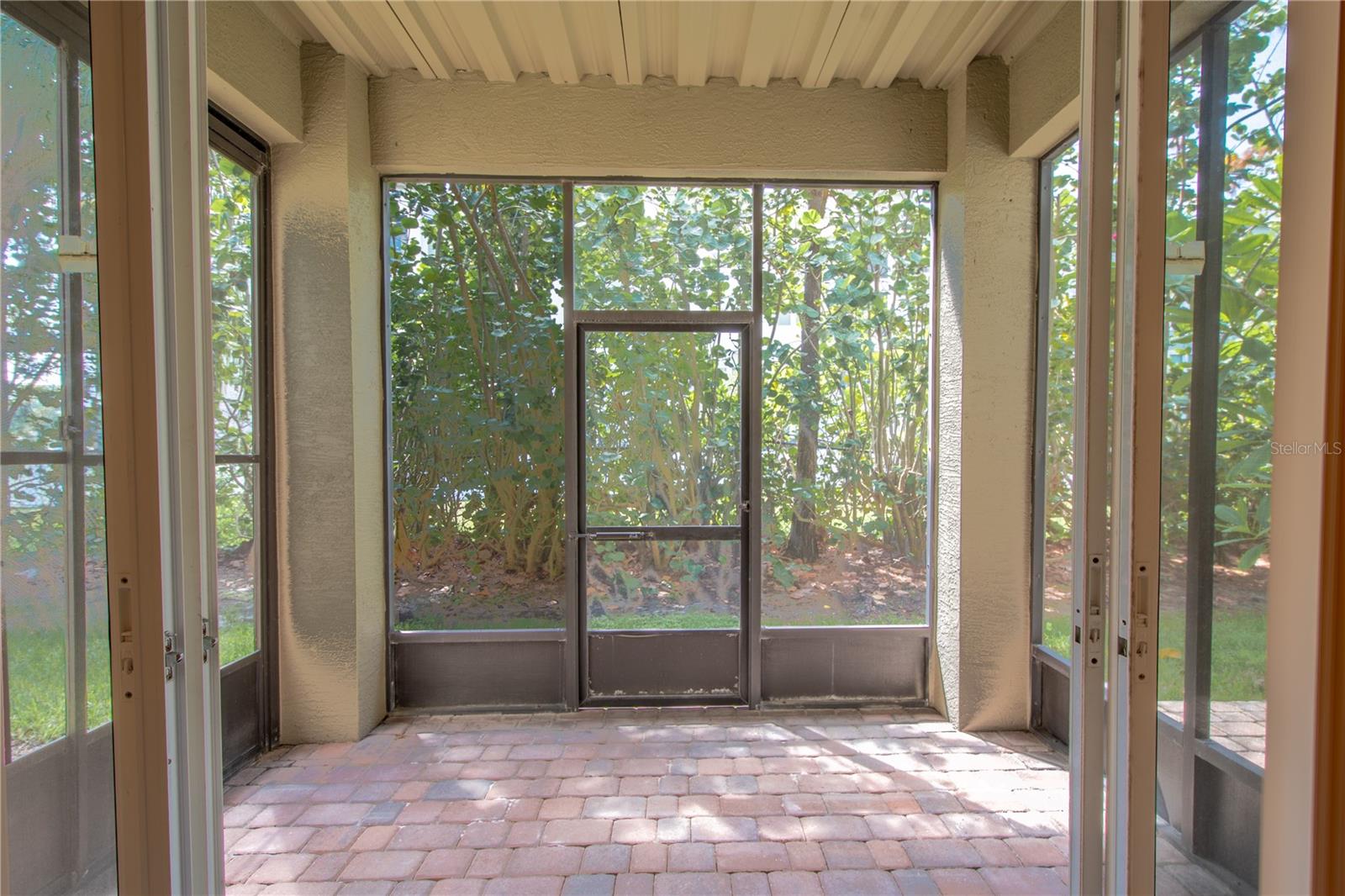 A spacious screened in porch with brick pavered floor opens up to the bonus/flex room on  the first level.