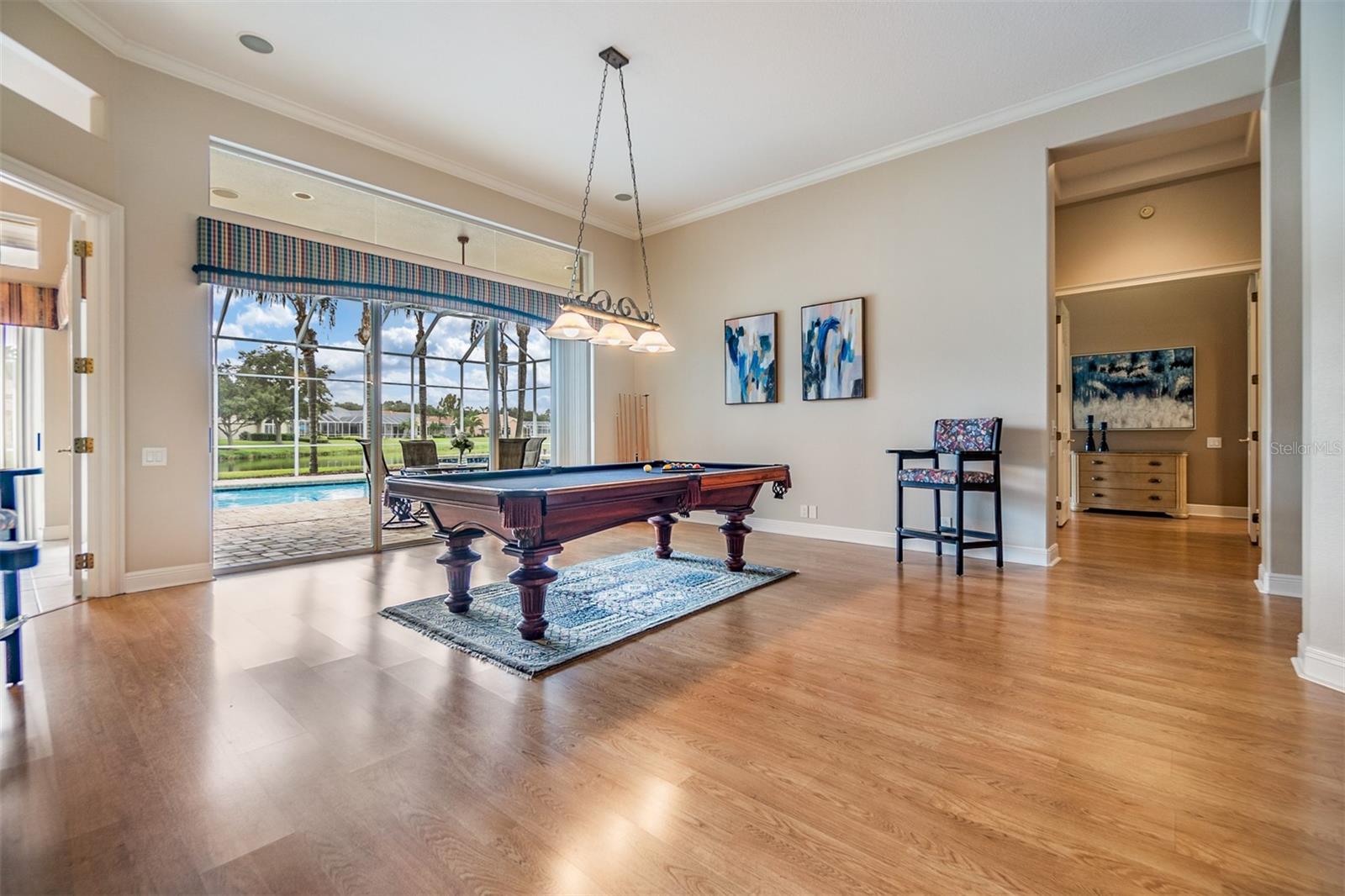 Formal Living Room or Game Room, Pergo Flooring, Crown Molding, views of the pool and pond.