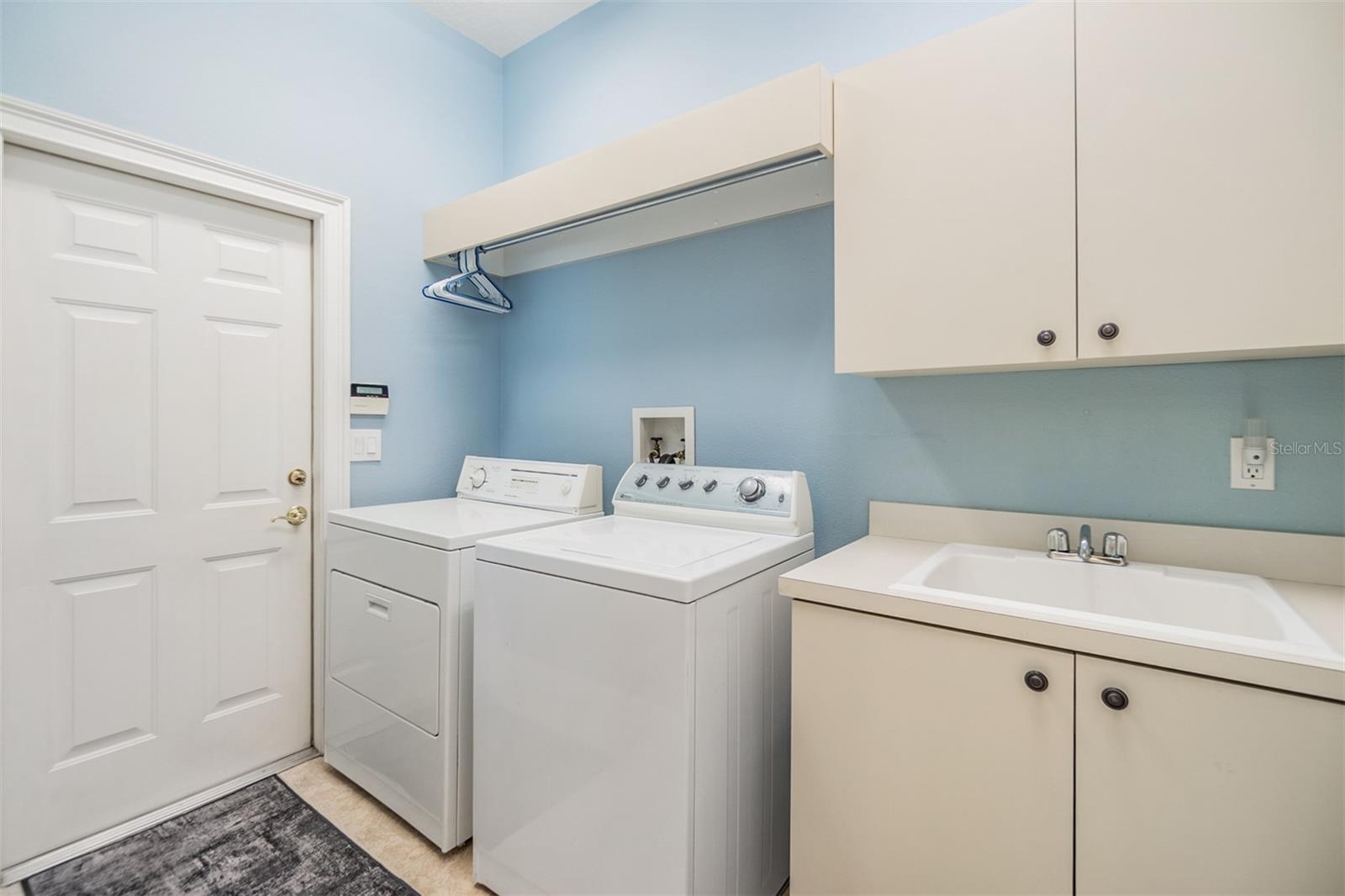 Laundry Room just off of the kitchen with utility sink and cabinets.