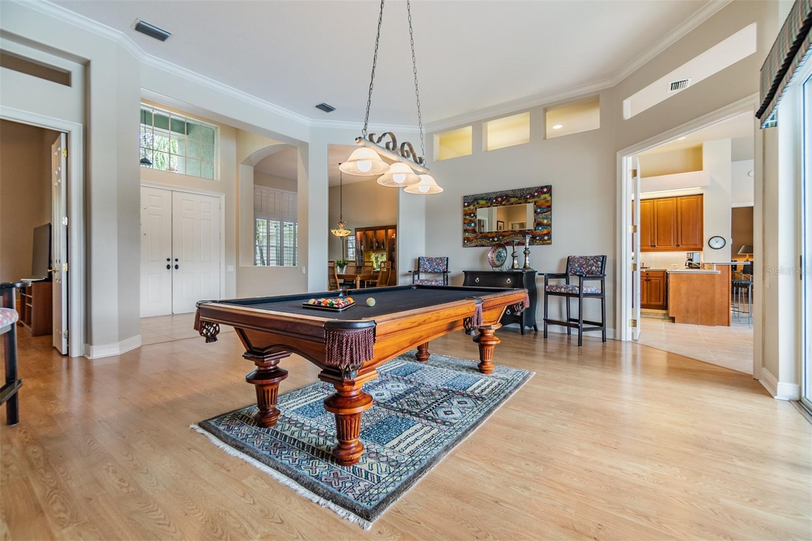 Formal Living Room or Game Room, Pergo Flooring, Crown Molding, views of the pool and pond. The Office is on the left of the photo.